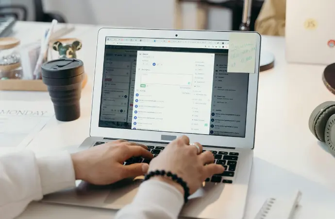 A person typing on a laptop, engaged in managing data within ServiceNow CMDB.