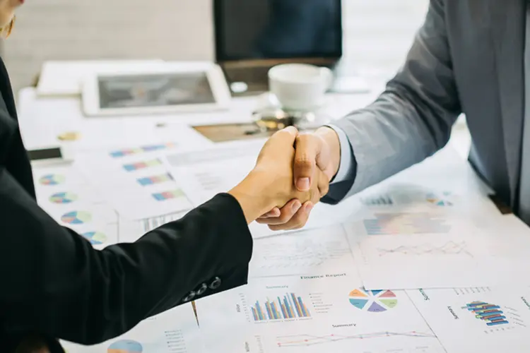 Two business professionals shaking hands during a meeting at LMTEQ at NBFC Connect, representing partnership and collaboration in BFSI
