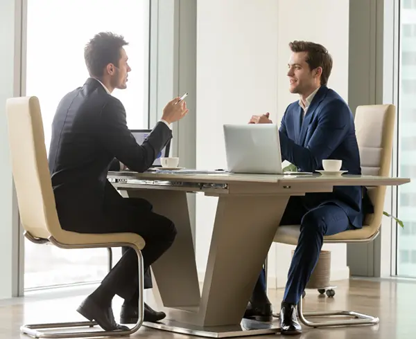 Two business professionals discussing ServiceNow modernization strategies at Manufacturing IT Summit 2026